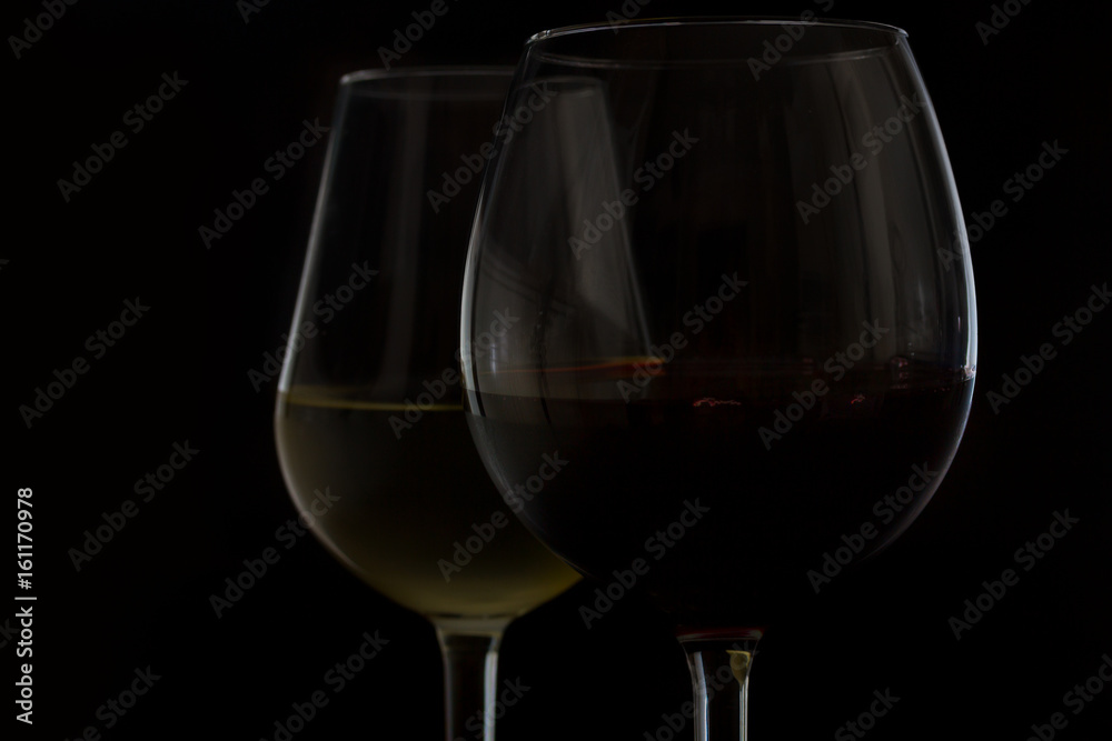 Wine glasses on black - two glasses of red and white wine close up