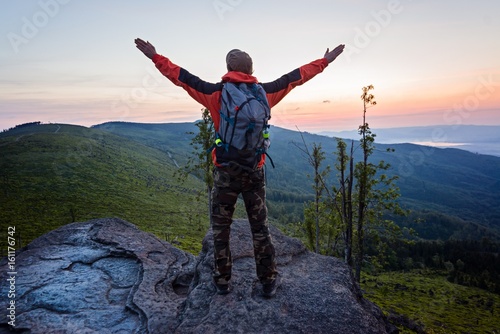 Man tourist at the top of the rock at sunrise.