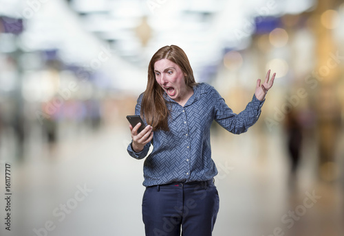 Pretty young business woman talking to mobil phone over blur background