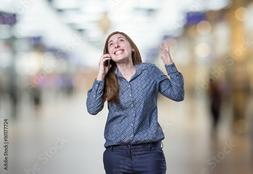 Pretty young business woman talking to mobil phone over blur background