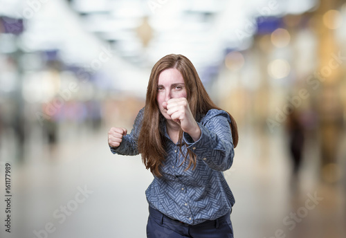 Pretty business woman with a raised fist over blur background