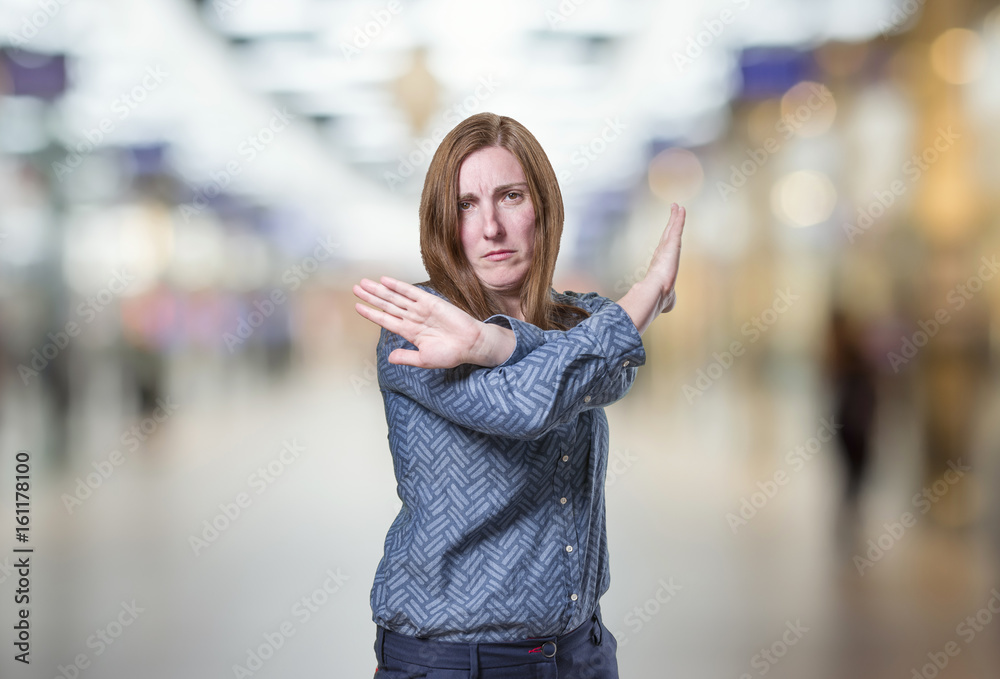 Fototapeta premium Young pretty girl making stop sign over blur background