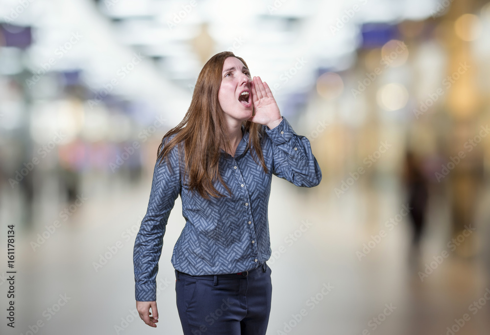 Pretty business woman screaming over blur background
