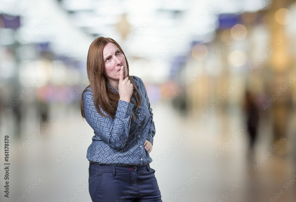 Pretty young businesswoman thinking over blur background