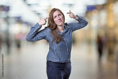 Pretty business woman making suicide gesture over blur background