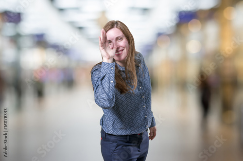 Pretty young business woman making a joke over blur background