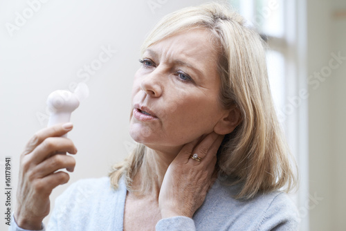 Mature Woman Experiencing Hot Flush From Menopause photo
