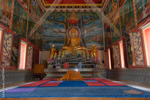 The Buddha image in the pavilion features beautiful wall paintings. © Chatree
