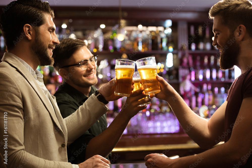 Cheerful young men toasting with beer