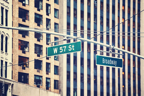 Vintage toned West 57 Street and Broadway hanging signs in Manhattan, New York City, USA.