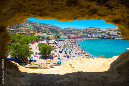 Fototapeta Naklejka Na Ścianę i Meble -  Matala beach through caves on the rocks that were used as a roman cemetery and at the decade of 70's were living hippies from all over the world, Crete, Greece