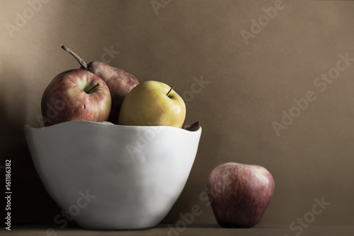 Ripe fruits in white vase of ceramic