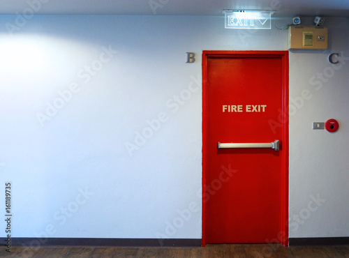 Fire exit emergency door red color and LED light made by metal material for protect life when in case of warning alarm sound in the building 