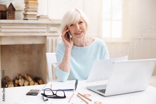 Ambitious elderly lady managing the project from home