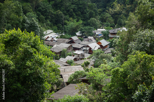 Scenery of rural village inside green area of tropical forest in Thailand.