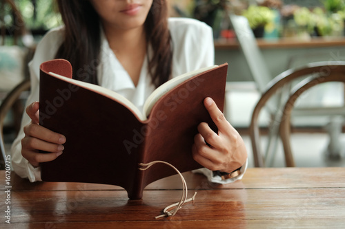 close up. young student woman sitting at library and reading book prepare for exam. image for business,education,book,people and portrait concept