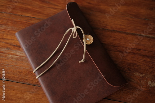 vintage leather notebook cover putting on wooden are background. image for business,education and abstract concept