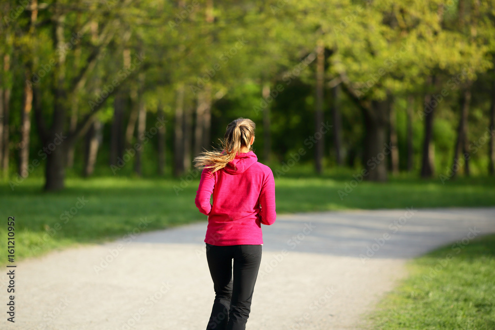 Young woman running on road in park, healthy sport lifestyle Young woman running on road in park, healthy sport lifestyle