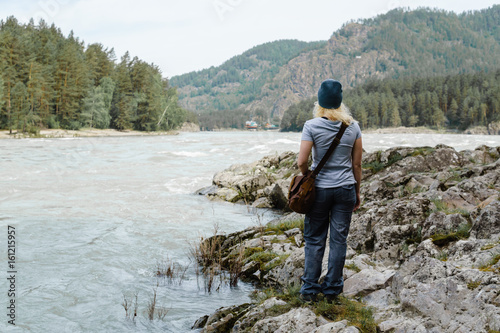 Young woman walking along the in the National Park. To dream of looking at the river.