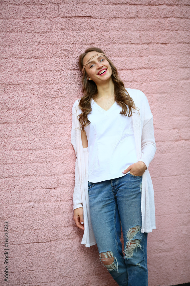 Happy girl smiling standing on pink brick background, upper half, looking camera, urban style, hipster Happy girl smiling standing on pink brick background, upper half, looking camera, urban style, hipster