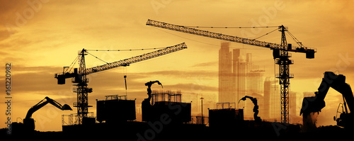 tower cranes at construction site and city background