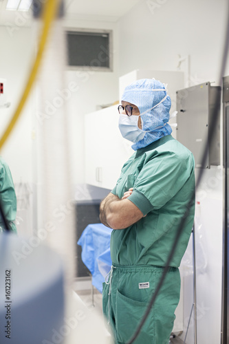 Surgeon standing in operation room waiting for preperations photo