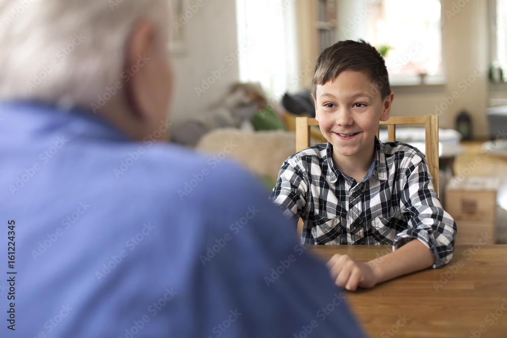 Young boy, 10 years old, talking to grandfather Young boy, 10 years old, talking to grandfather