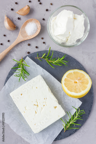 Ingredients for feta, cream cheese, rosemary, lemon and garlic dip on slate board, top view
