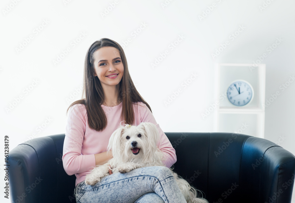 Young beautiful woman with cute dog sitting on sofa at home Young beautiful woman with cute dog sitting on sofa at home