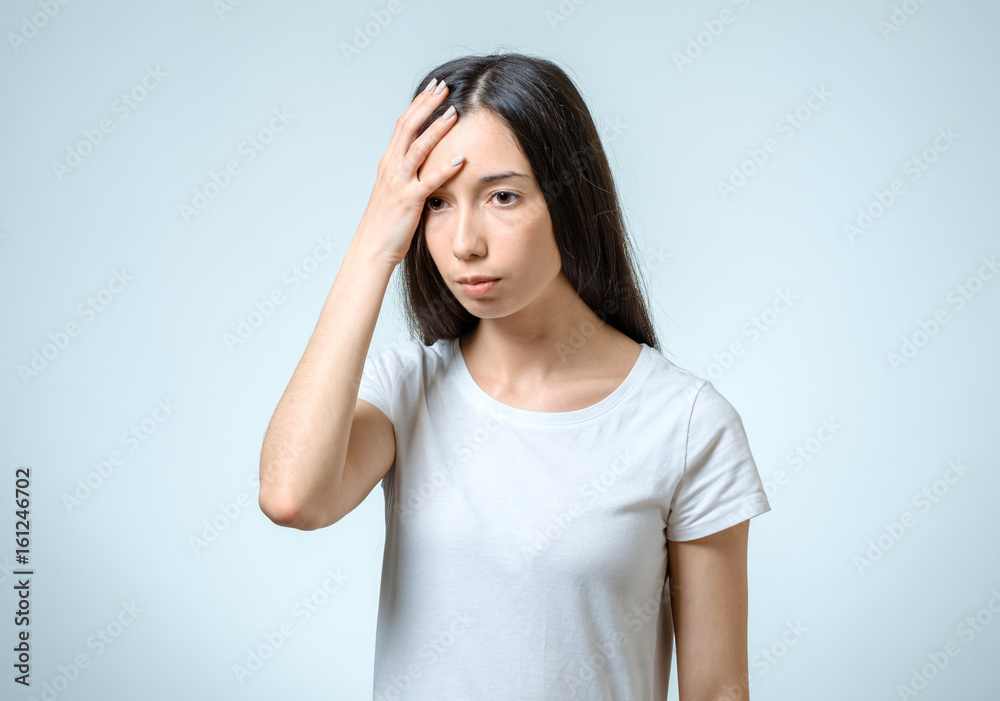 Young pretty brunette girl touching her head Young pretty brunette girl touching her head