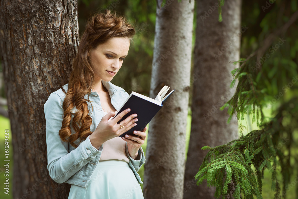 outdoors portrait of a beautiful girl reading book outdoors portrait of a beautiful girl reading book