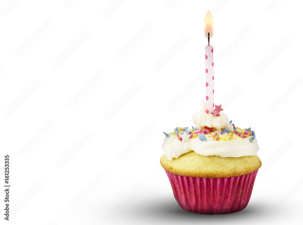 Single cup cake with lit pink spotted candle isolated on white background Single cup cake with lit pink spotted candle isolated on white background