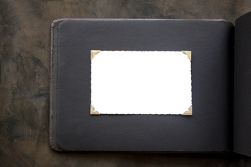 Photo frame - real old photo with white blank space for copy photo with gold coloured photo holder corners onto black vintage album paper page - top view background with space for text