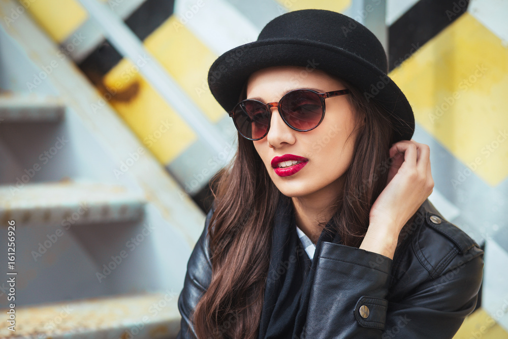 Young stylish woman in a city street drinking coffee . Young stylish woman in a city street drinking coffee .