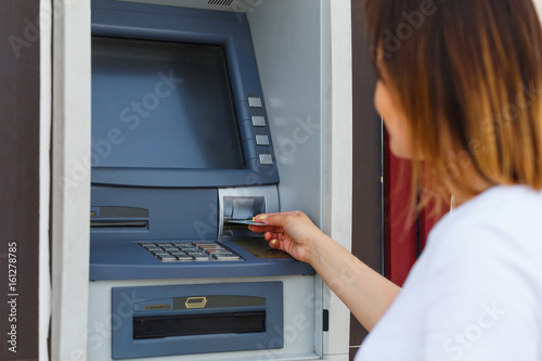 Young beautiful woman using an ATM