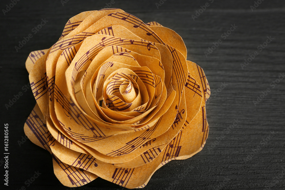 Fototapeta premium Beautiful rose made of music notes on wooden table closeup