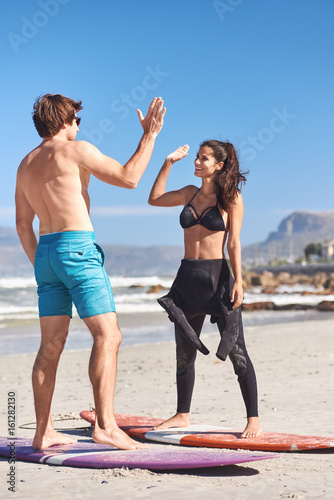 Private Surf Lesson On Beach, woman highfives instructor