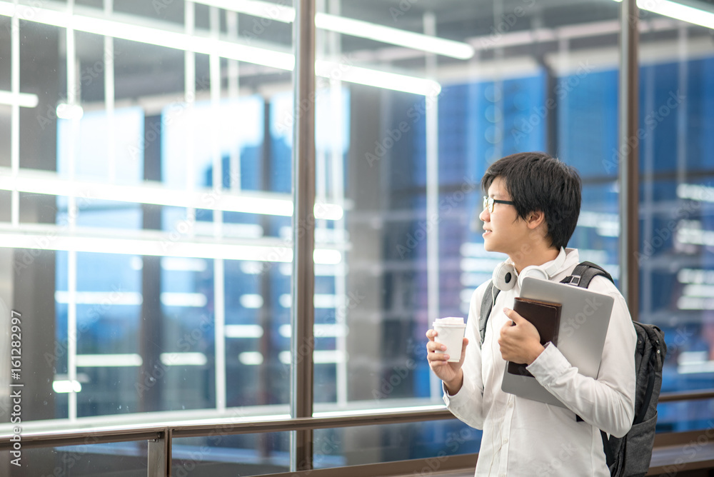 Young Asian university student holding laptop and coffee cup, study and learning lifestyle in college with international education concepts Young Asian university student holding laptop and coffee cup, study and learning lifestyle in college with international education concepts