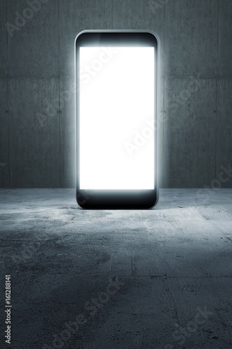 Leuchtendes Smartphone steht auf Beton Hintergrund photo