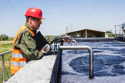 Worker monitor filtering industrial water, he adjust some pump.