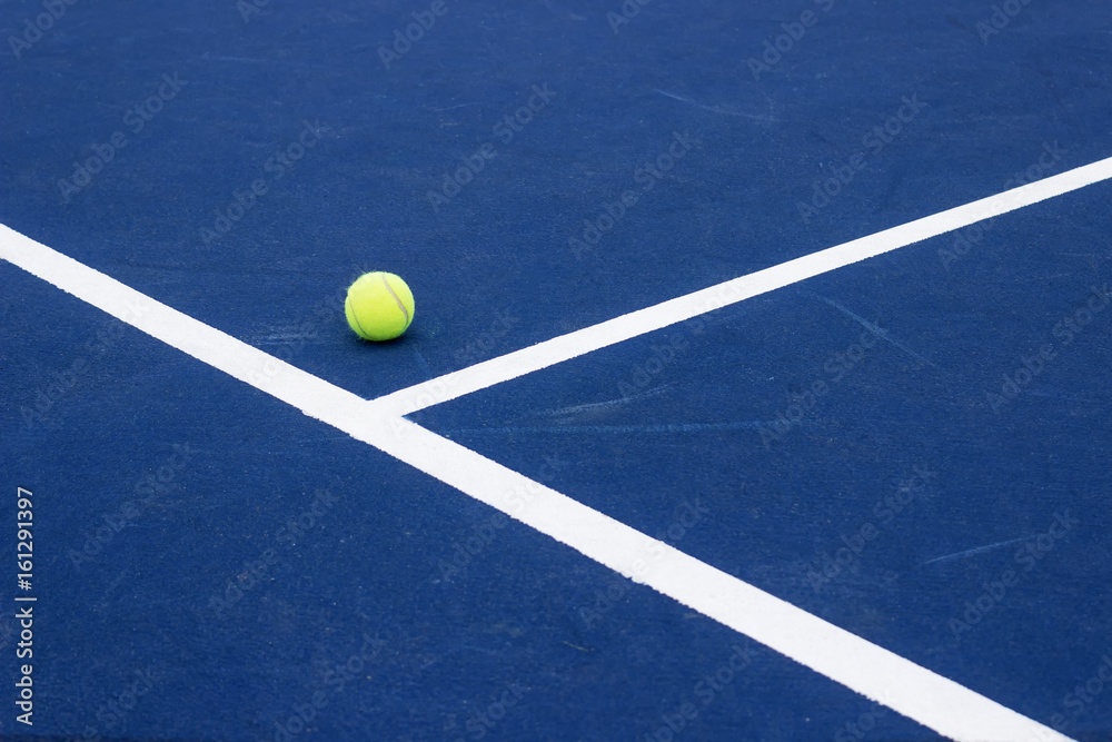 Tennis ball on tennis court. Blue hard surface.