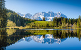 Idyllic alpine scenery, snowy mountains mirroring in a small lake, Kitzbühel, Tyrol, Austria