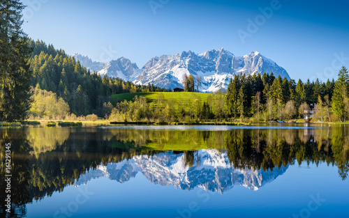 Idyllic alpine scenery, snowy mountains mirroring in a small lake, Kitzbühel, Tyrol, Austria
