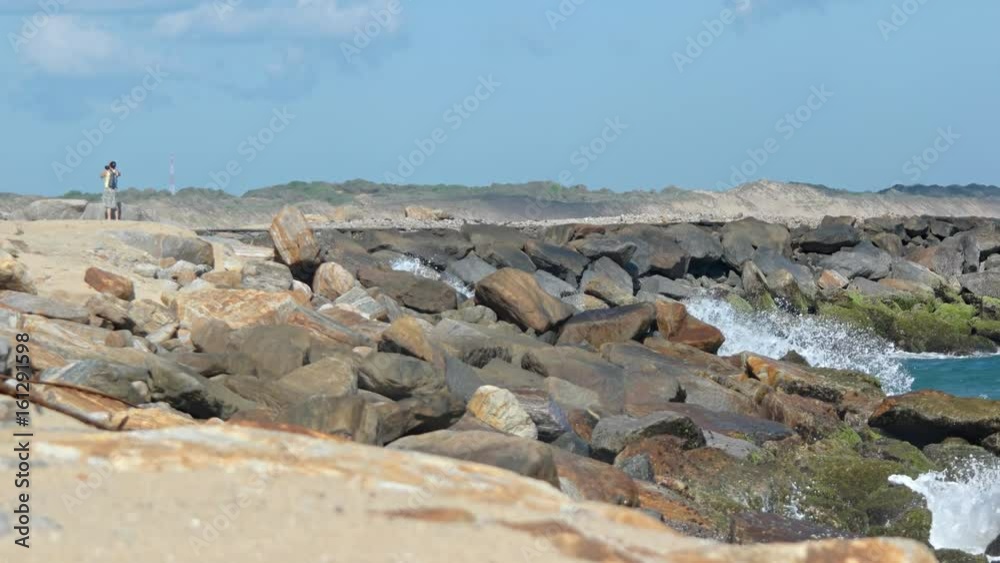 Tourist Taking Photos on Stone Breakwater in Sri Lanka Tourist Taking Photos on Stone Breakwater in Sri Lanka