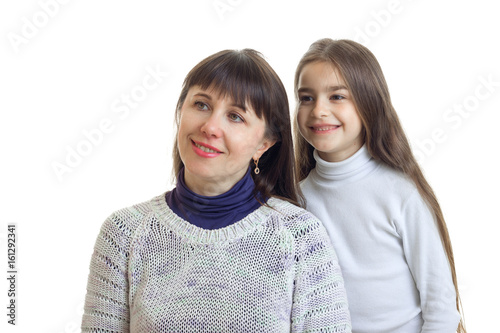 mom and daughter smiling and looking to the side