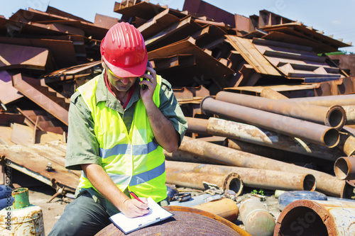 Man talking and write it down on junkyard