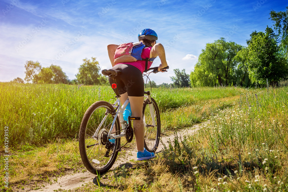 Young woman riding a bicycle in the field Young woman riding a bicycle in the field