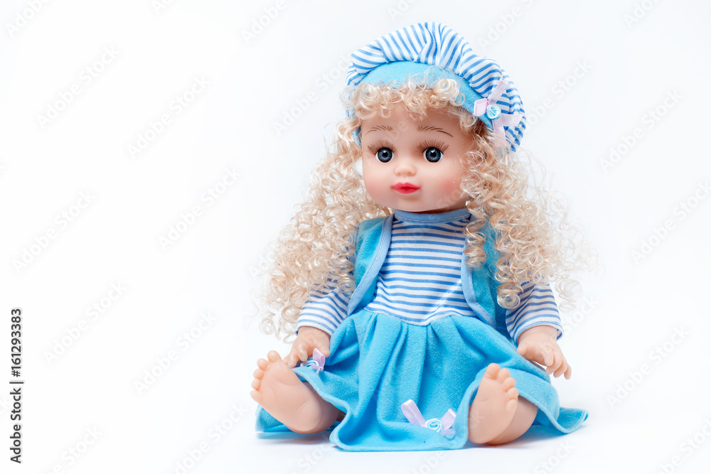 Blond baby doll in blue and white striped dress and hat on white background Blond baby doll in blue and white striped dress and hat on white background