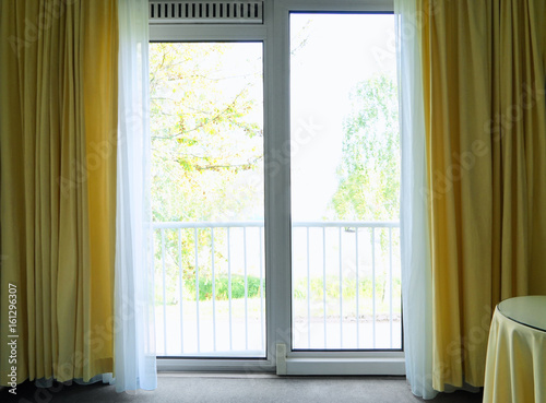 Big window with yellow curtains in apartment