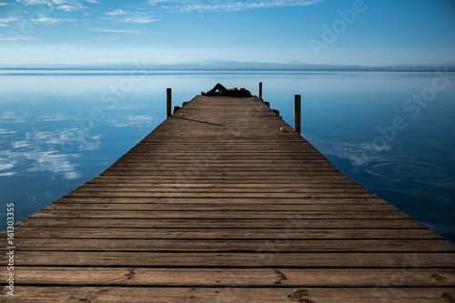 A person enjoys the tranquility offered by the calm of the pier